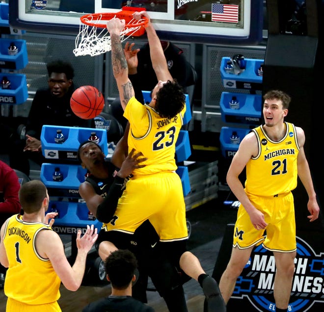 Michigan Wolverines forward Brandon Johns Jr. (23) dunks on Florida State Seminoles center Tanor Ngom (34) during the Sweet Sixteen round of the 2021 NCAA Tournament on Sunday, March 28, 2021, at Bankers Life Fieldhouse in Indianapolis, Ind.
