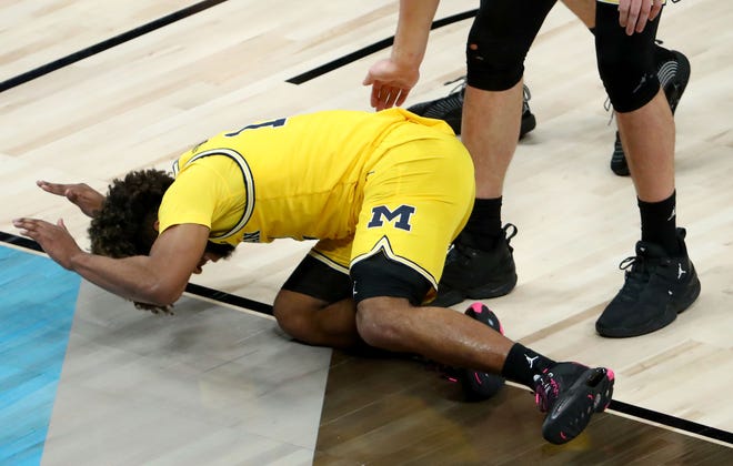 Michigan Wolverines guard Mike Smith (12) smacks the floor after a charge is called on Florida State during the Sweet Sixteen round of the 2021 NCAA Tournament on Sunday, March 28, 2021, at Bankers Life Fieldhouse in Indianapolis, Ind.