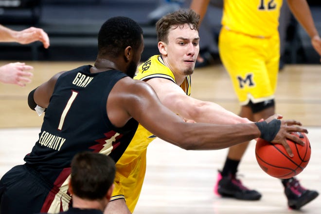 Michigan Wolverines guard Franz Wagner (21) and Florida State Seminoles forward RaiQuan Gray (1) reach for the ball during the Sweet Sixteen round of the 2021 NCAA Tournament on Sunday, March 28, 2021, at Bankers Life Fieldhouse in Indianapolis, Ind.