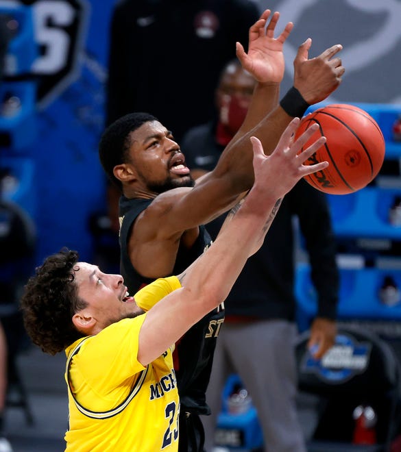 Florida State Seminoles forward Malik Osborne (10) and Michigan Wolverines forward Brandon Johns Jr. (23) fight for a rebound during the Sweet Sixteen round of the 2021 NCAA Tournament on Sunday, March 28, 2021, at Bankers Life Fieldhouse in Indianapolis, Ind.