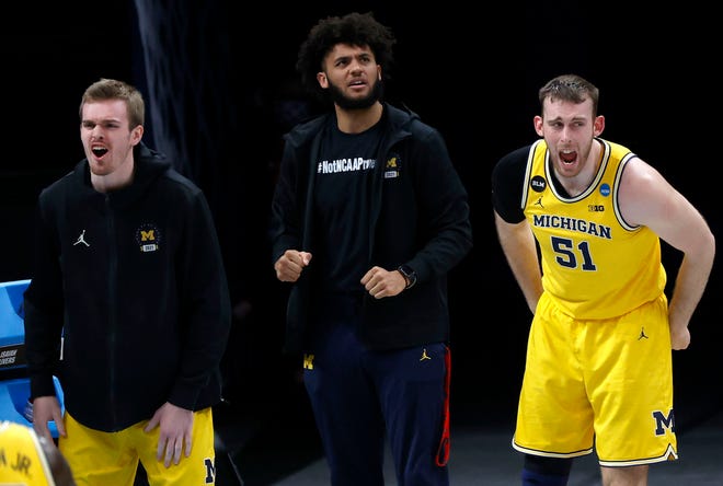 The Michigan bench cheers after an offensive foul is called on Florida State during the Sweet Sixteen round of the 2021 NCAA Tournament on Sunday, March 28, 2021, at Bankers Life Fieldhouse in Indianapolis, Ind.