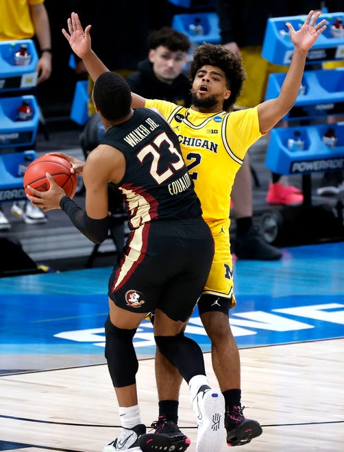 Michigan Wolverines guard Mike Smith (12) takes a charge from Florida State Seminoles guard M.J. Walker (23) during the Sweet Sixteen round of the 2021 NCAA Tournament on Sunday, March 28, 2021, at Bankers Life Fieldhouse in Indianapolis, Ind.