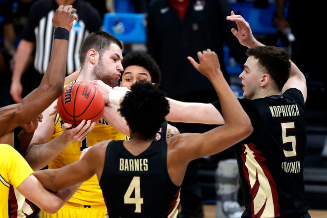 Florida State Seminoles center Balsa Koprivica (5) knocks the ball out of Michigan Wolverines center Hunter Dickinson (1) hand during the Sweet Sixteen round of the 2021 NCAA Tournament on Sunday, March 28, 2021, at Bankers Life Fieldhouse in Indianapolis, Ind.