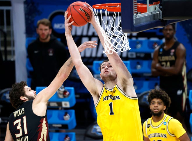 Michigan Wolverines center Hunter Dickinson (1) pulls down a rebound over Florida State Seminoles guard Wyatt Wilkes (31) during the Sweet Sixteen round of the 2021 NCAA Tournament on Sunday, March 28, 2021, at Bankers Life Fieldhouse in Indianapolis, Ind.