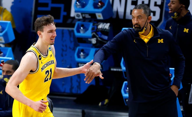 Michigan head coach Juwan Howard high fives Michigan Wolverines guard Franz Wagner (21) after a turnover during the Sweet Sixteen round of the 2021 NCAA Tournament on Sunday, March 28, 2021, at Bankers Life Fieldhouse in Indianapolis, Ind.