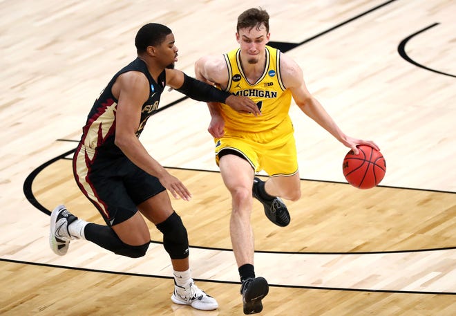 Michigan Wolverines guard Franz Wagner (21) moves the ball down court as Florida State Seminoles guard M.J. Walker (23) during the Sweet Sixteen round of the 2021 NCAA Tournament on Sunday, March 28, 2021, at Bankers Life Fieldhouse in Indianapolis, Ind.