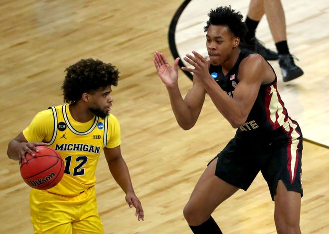 Florida State Seminoles guard Scottie Barnes (4) claps in the face of Michigan Wolverines guard Mike Smith (12) during the Sweet Sixteen round of the 2021 NCAA Tournament on Sunday, March 28, 2021, at Bankers Life Fieldhouse in Indianapolis, Ind.