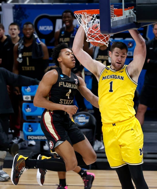 Michigan Wolverines center Hunter Dickinson (1) dunks over Florida State Seminoles guard Scottie Barnes (4) during the Sweet Sixteen round of the 2021 NCAA Tournament on Sunday, March 28, 2021, at Bankers Life Fieldhouse in Indianapolis, Ind.